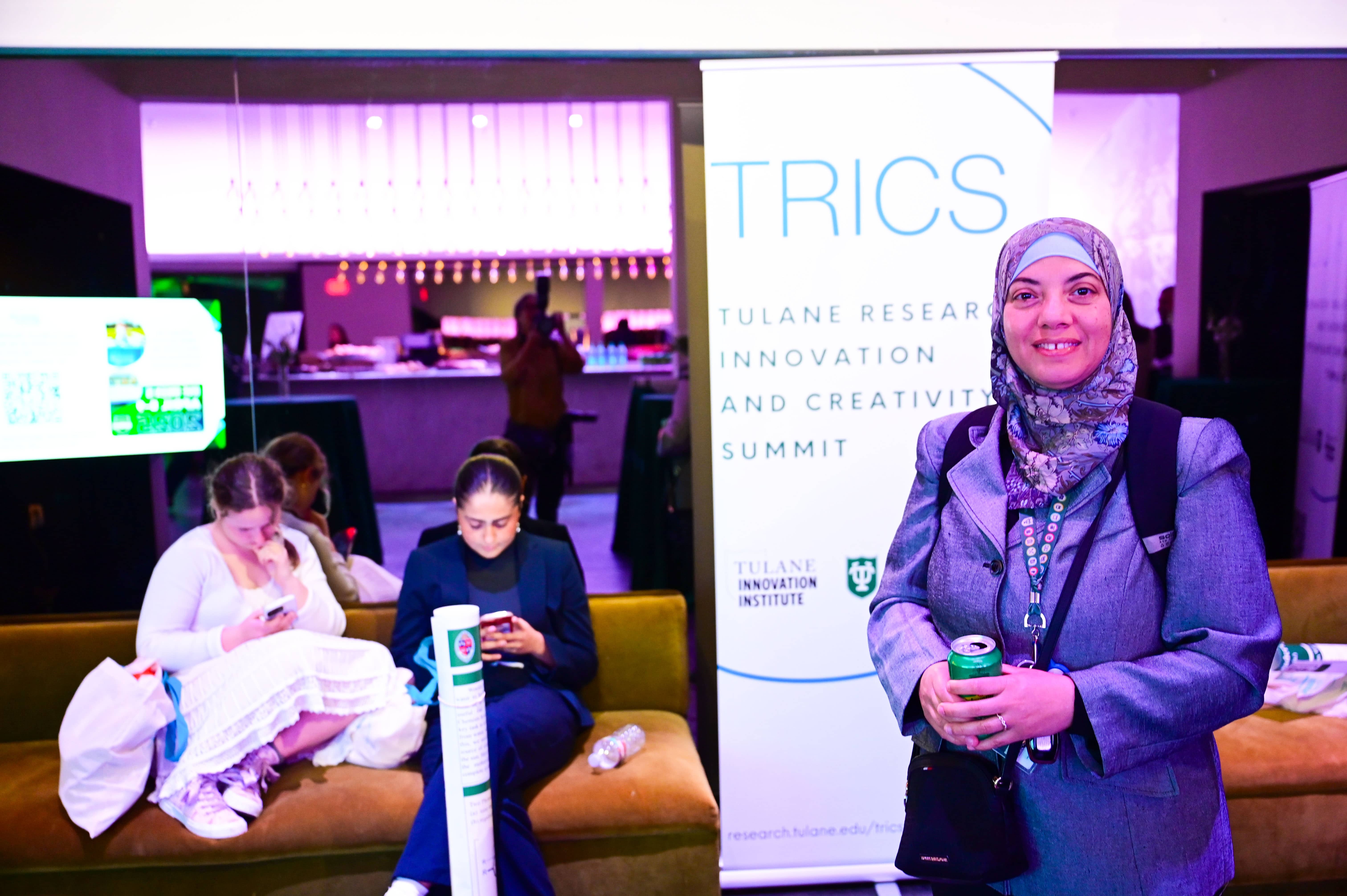 Smiling woman in a headscarf at the Tulane Research Innovation and Creativity Summit.